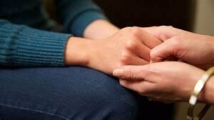 Women holding hands showing support for victim of DV